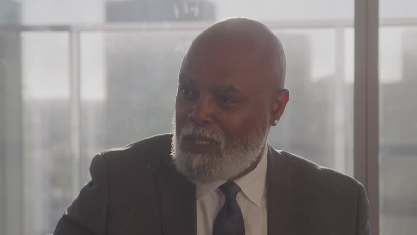 Man in suit in an office environment talking
