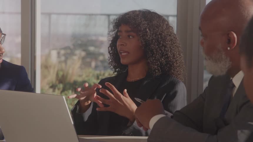 Close up of a group of black executives discussing at a table in a meeting room during daytime