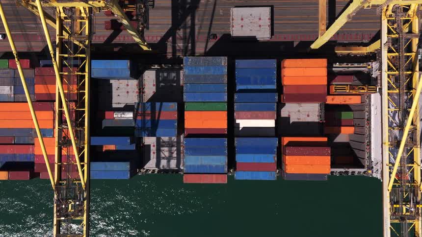 Aerial view of a cargo ship loading containers at a port