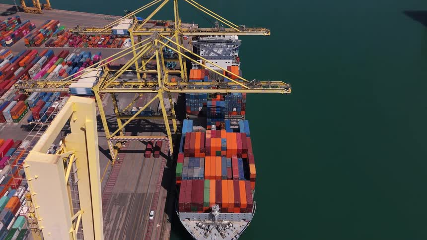 The ship by the harbor is loaded with shipping containers