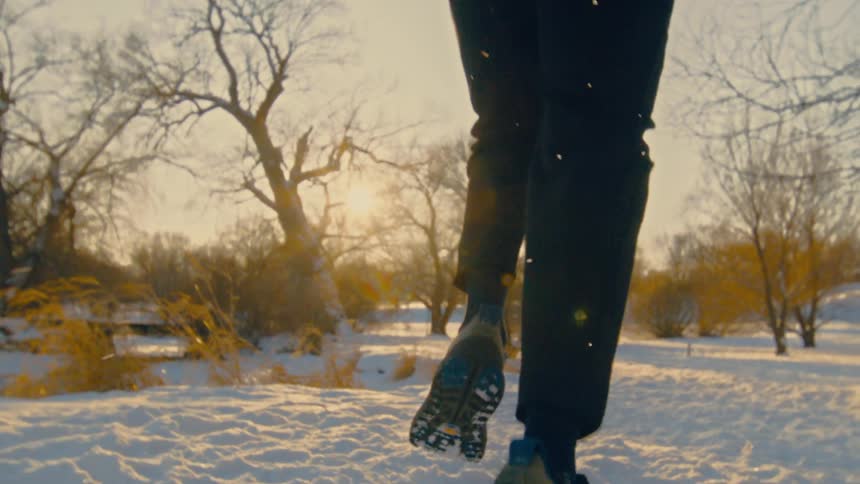A person runs through the snow on a sunny winter day