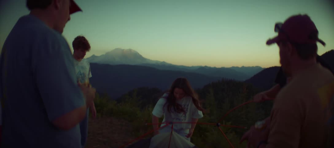 Group of people camping in the mountains at dusk