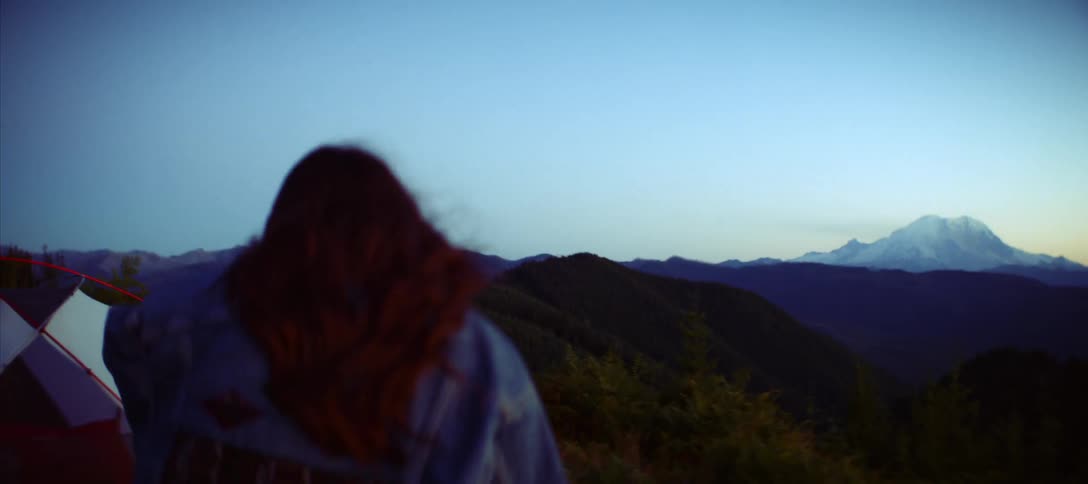 Redhaired woman walking through a mountain camp