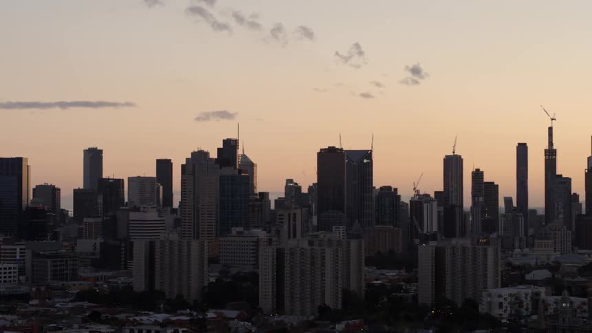 The tall buildings line the dawn sky