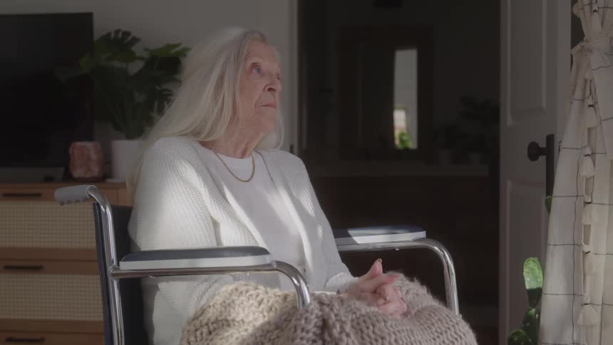 Thoughtful elderly woman sitting in a wheelchair