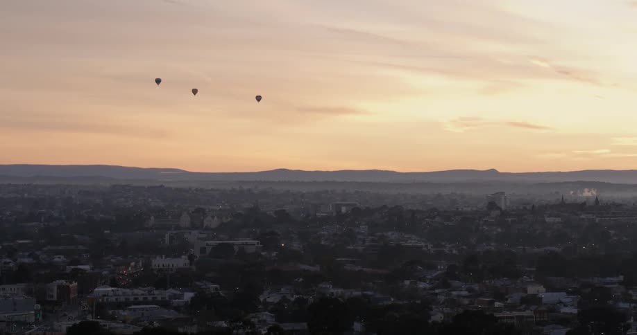 A view of some hot air balloons at dusk off in the distance