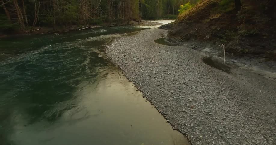 A view of a river flowing through and around some woods