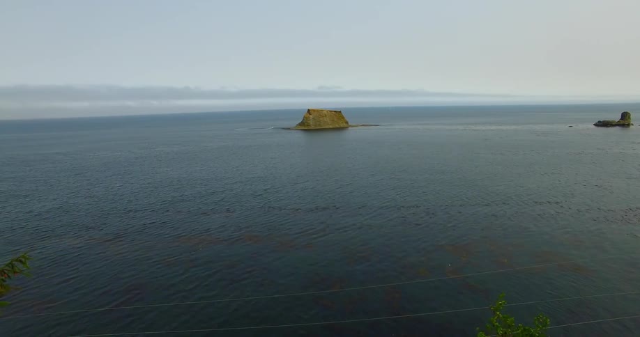 Huge rock mass surrounded by ocean waters