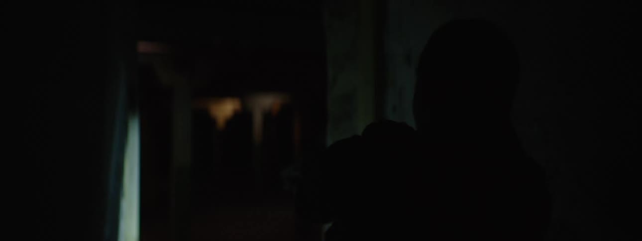 Female police officer searches a dark building holding her handgun and a flashlight