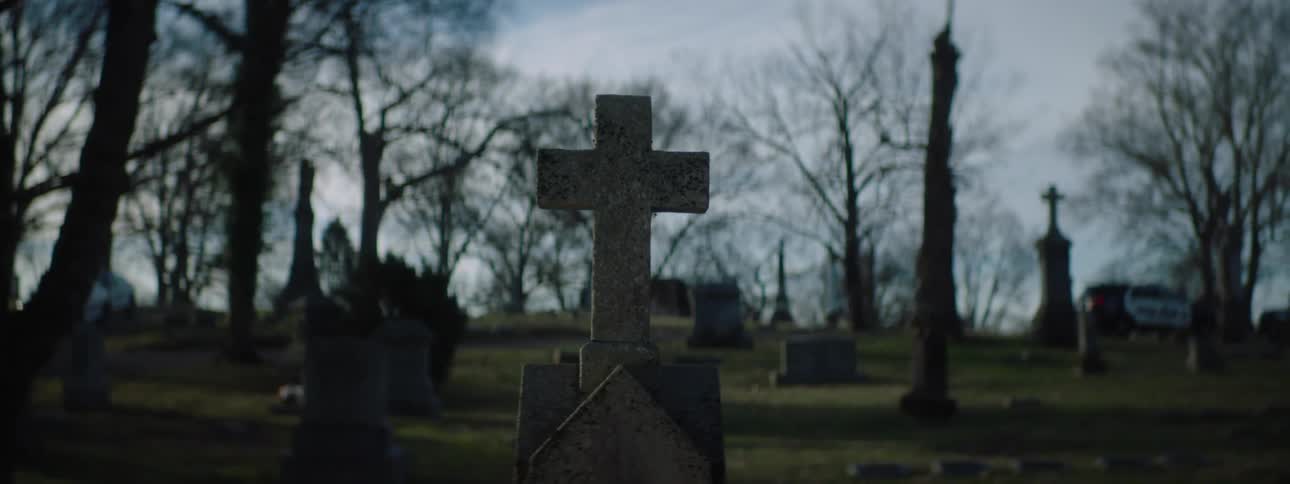 The graveyard has many different shaped tombstones