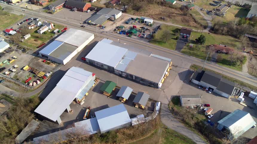 Aerial view of several buildings located next to a road where cars drive past