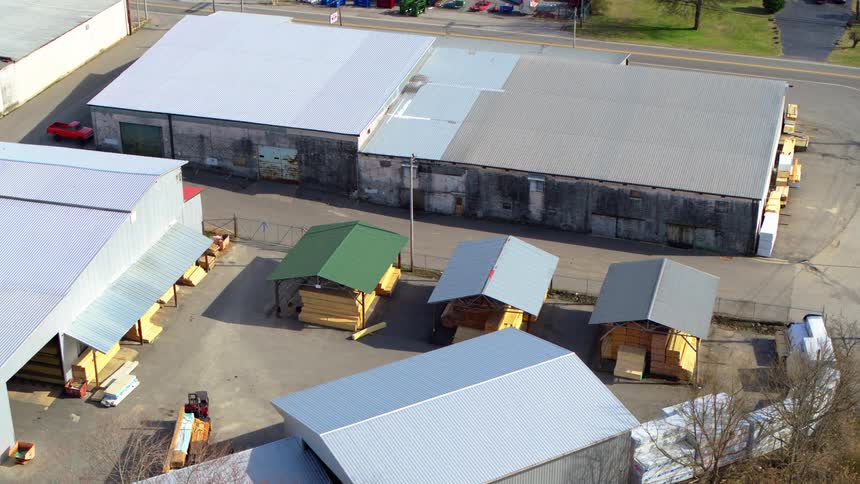 Aerial of two people riding bicycles in a lumberyard
