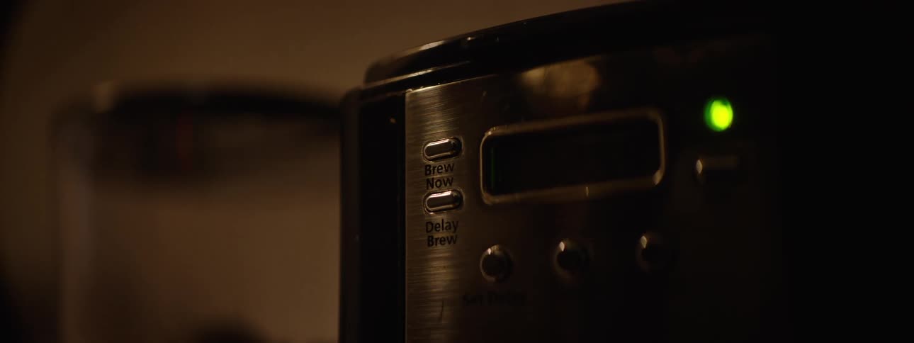 Person sets the coffee machine to brewing immediately instead of choosing a delayed brew