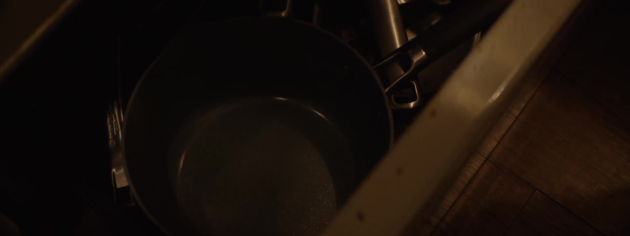 Person opening a drawer and taking out a pan
