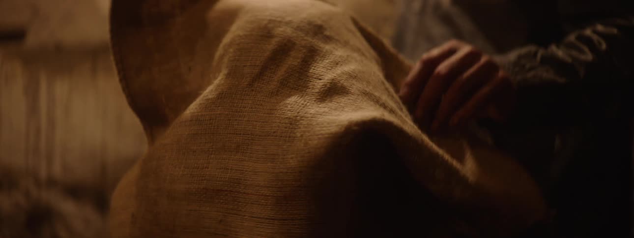A man removes the potato sack from the womans head