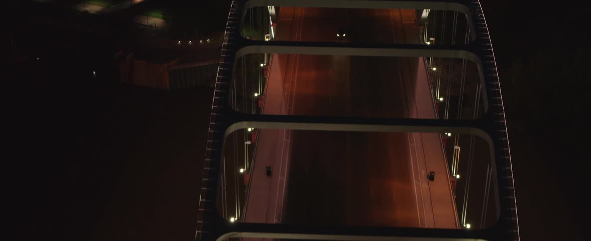Cars crossing a lit bridge at night