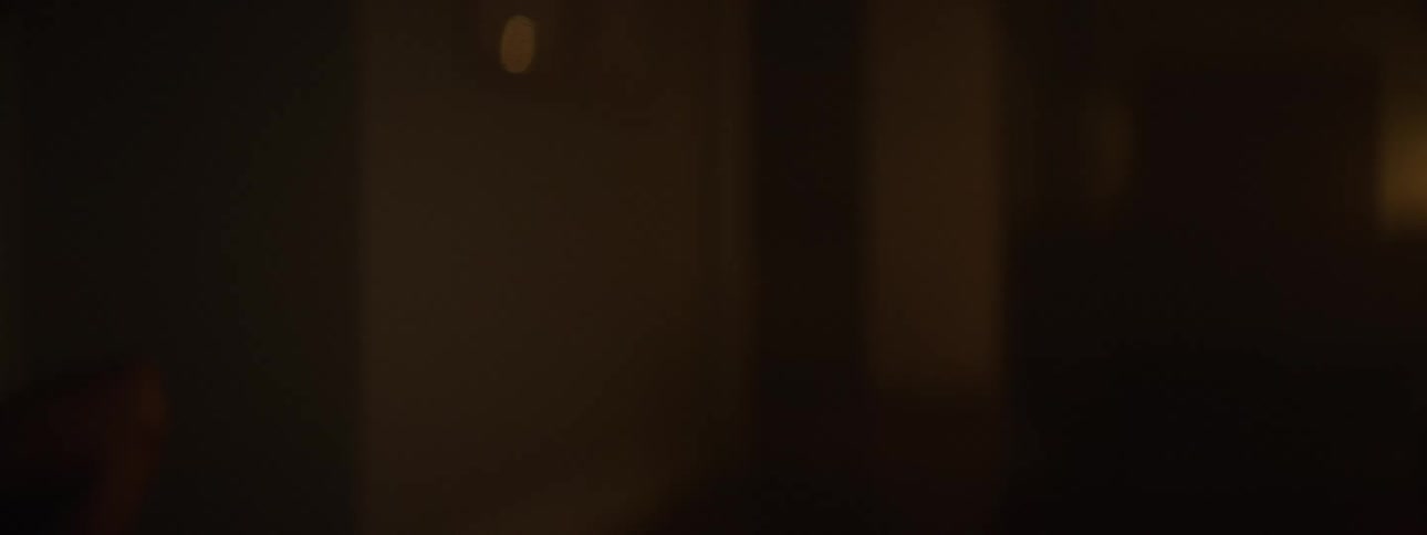A young woman doing crunches in an indoor setting with low light