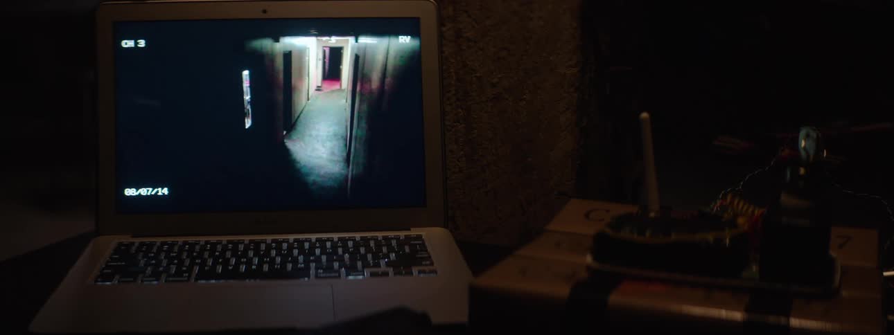 Laptop displaying security camera footage next to an improvised explosive device