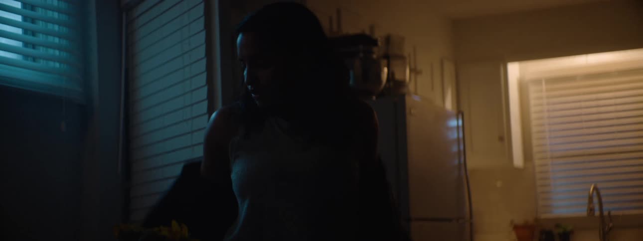 Woman arriving home taking off her coat and going to the kitchen