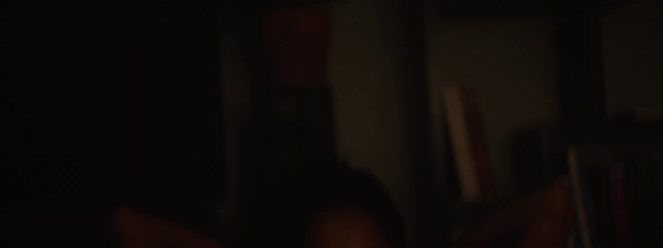 Woman in a dark indoor environment doing situps