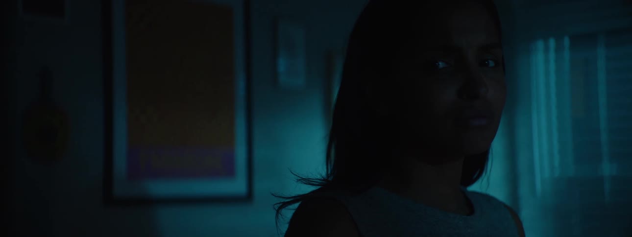 Close up portrait of a young black woman walking around a dark room at night