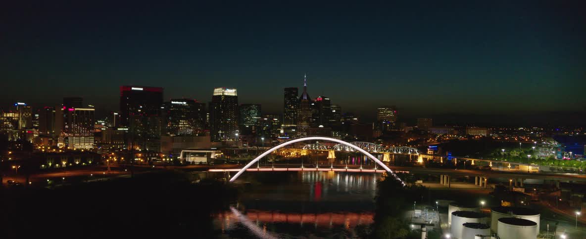 Aerial view of an illuminated bridge in a metropolis at night