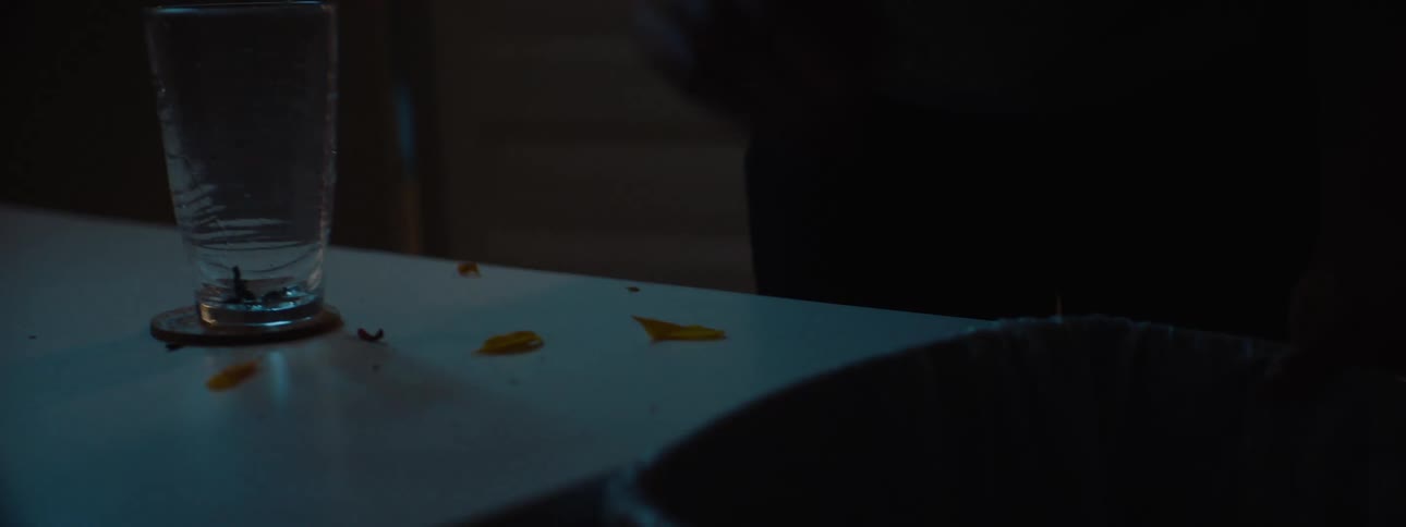 Woman cleaning a table with a glass and scattered petals