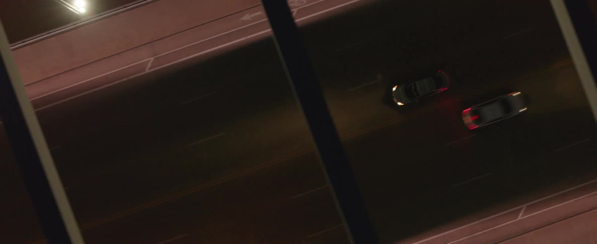 Aerial view of an automobile driving along a roadway at night