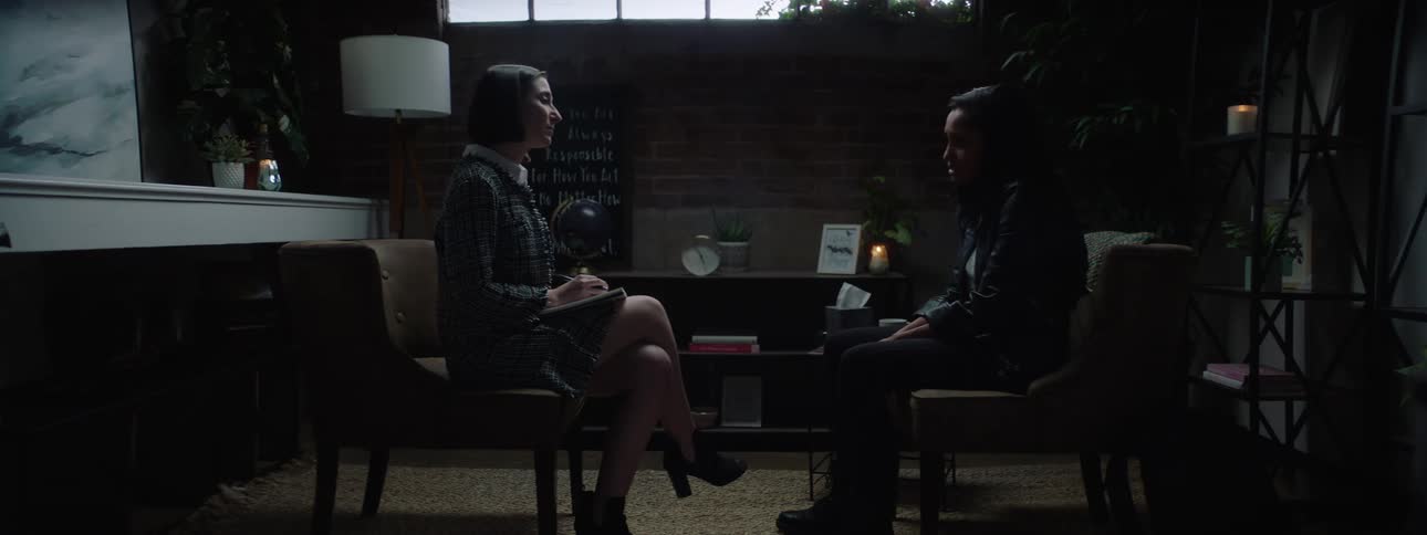 Woman and a man sitting across from each other in a room talking