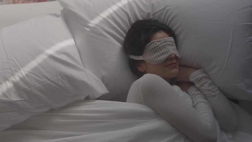 Woman with eye patch sleeping in bed