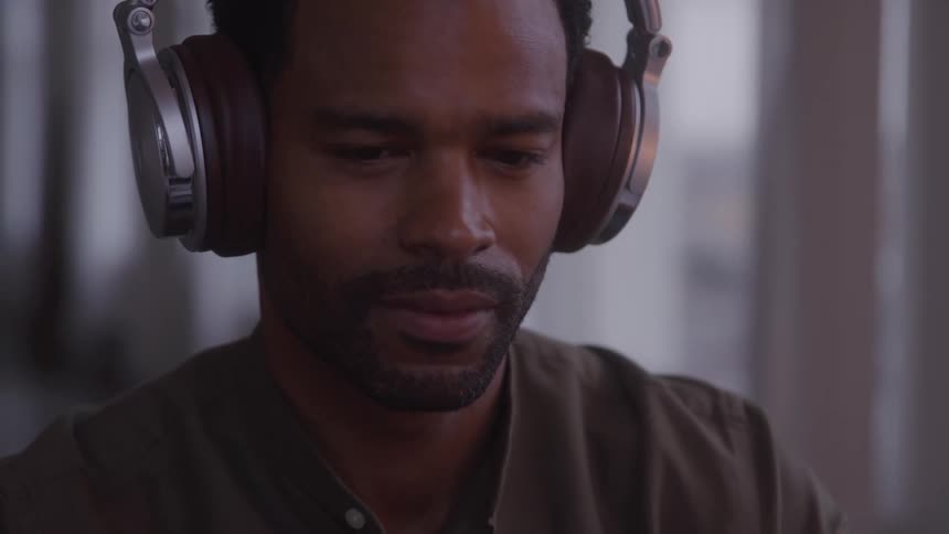 A young man wearing headphones in an indoor setting
