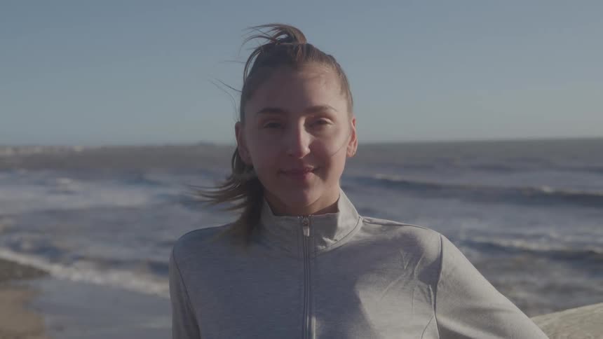 The woman is smiling on the beach