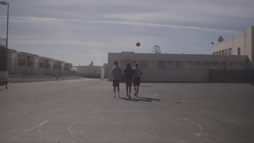 The basketball players walk side by side on the court