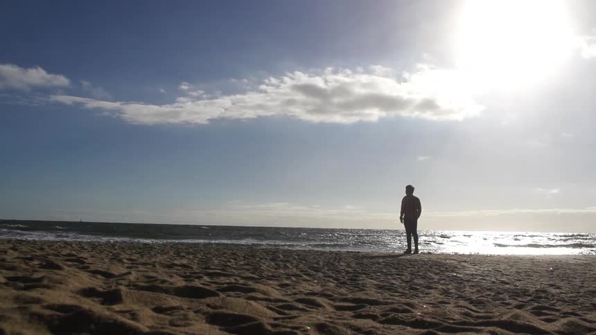Man standing on a beach looking at the scenery