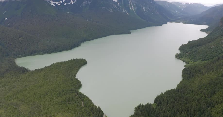 Vast lake surrounded by dense forests and mountains