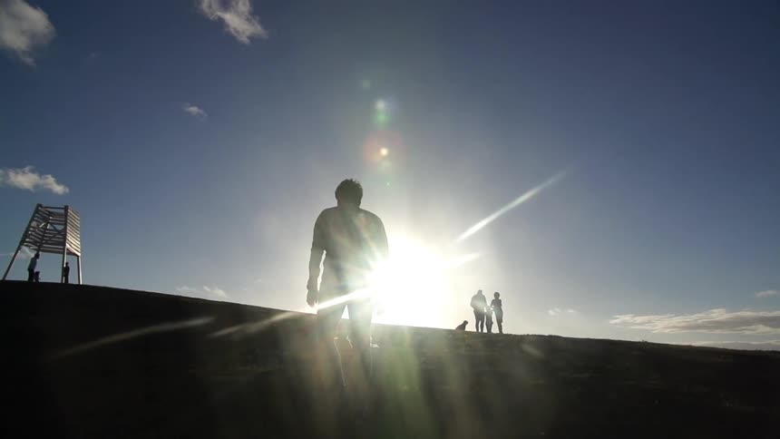 Silhouettes of people on a sunny hill