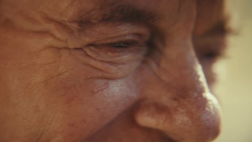 Elderly man laughing excitedly indoors his face lit up with joy and energy