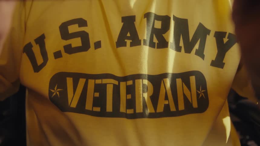 The man is wearing a shirt with us army veteran printed on it