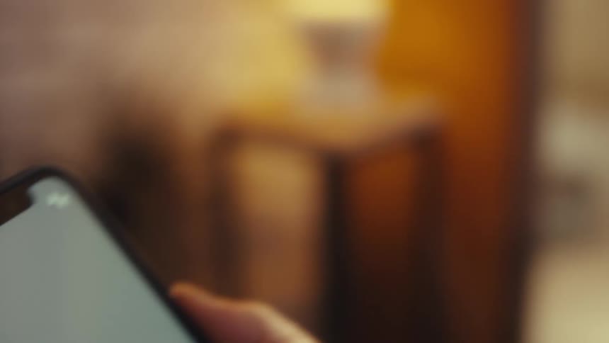 Elderly man sitting interacting with a smartphone