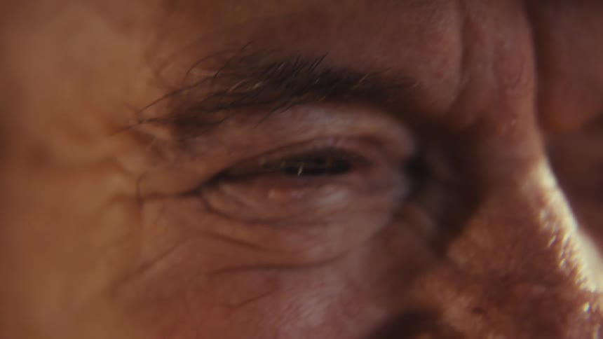 Smiling elderly eyes sit below a best grandpa cap