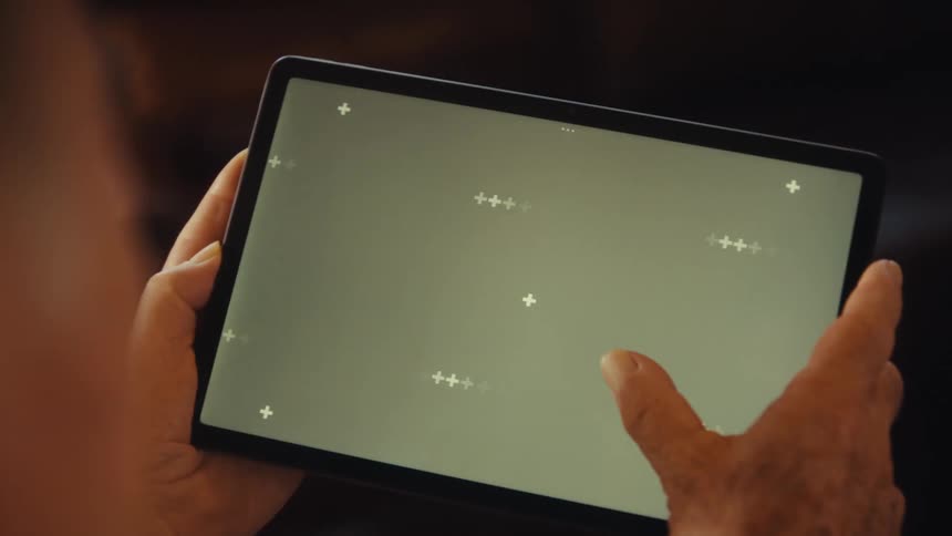 Pair of hands of an elderly man interacting with a tablet