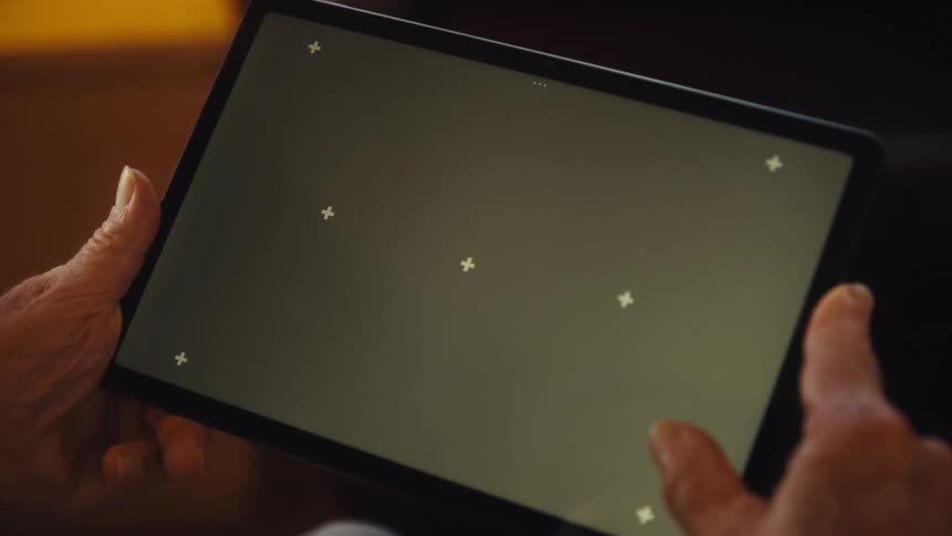 Elderly hands hold a tablet