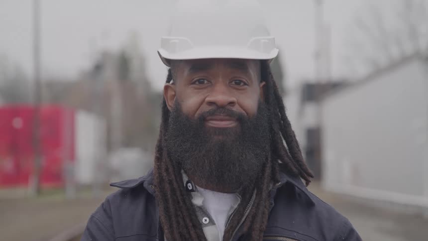 The man is wearing a white hard hat