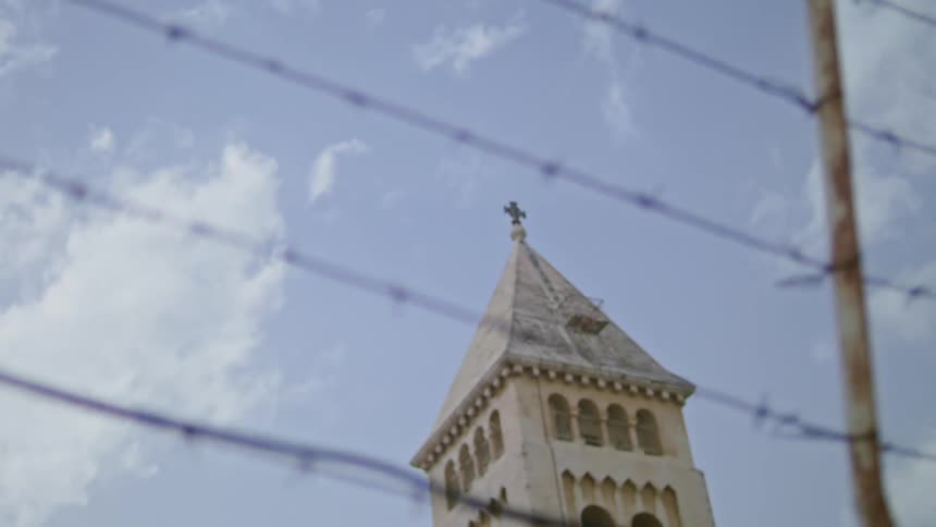 Barbed wire fence and a building behind it
