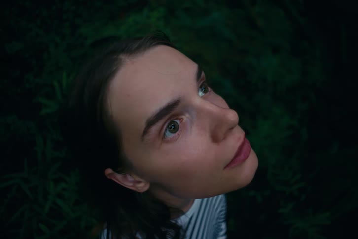 A closeup shot shows a womans head and face looking up