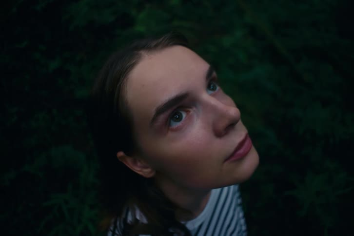 A closeup shot shows a womans head and face looking up