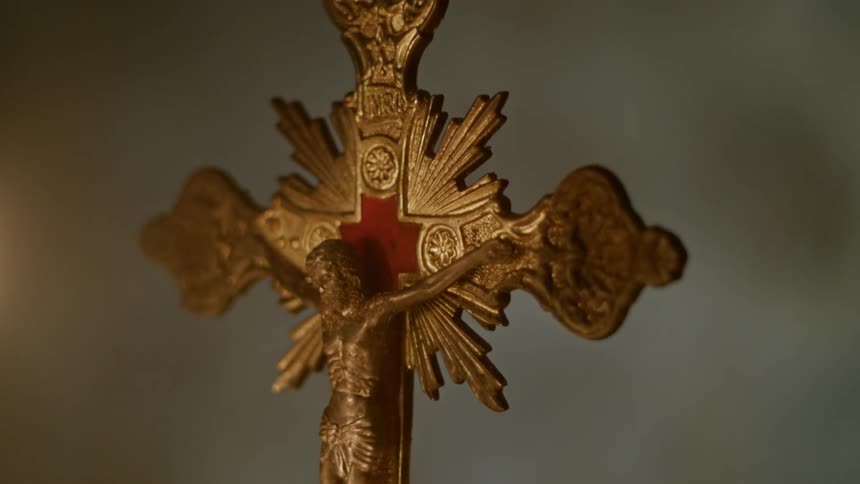 A candle burns near a crucifix