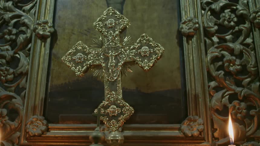 An elaborate cross near some candles