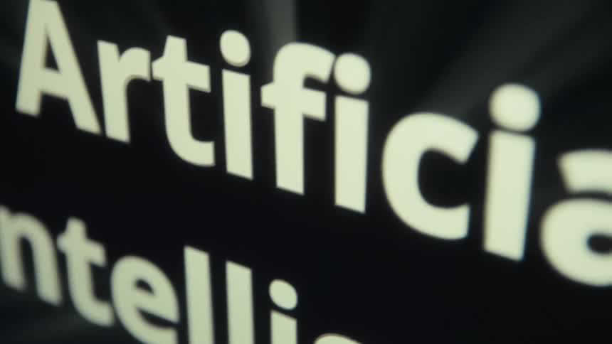 This video features a closeup shot of the words artificial and intelligence in a white font against a black background the camera moves along the letters as they come into focus before fading to black