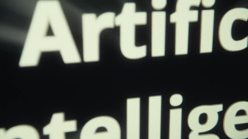 Closeup of a screen displaying artificial intelligence in bold on a dark background